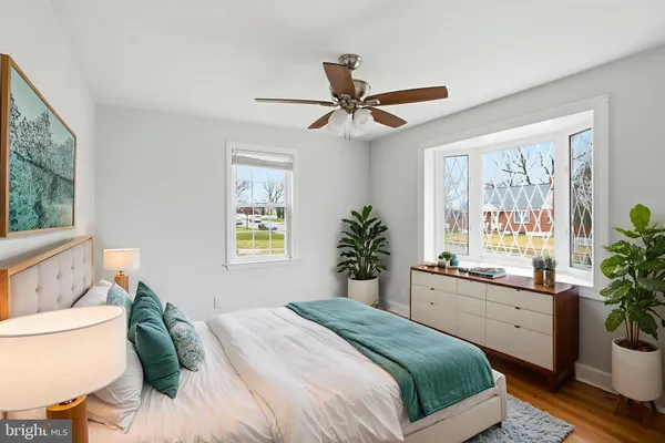 a bedroom with a bed and a large window