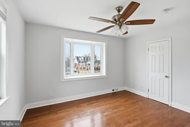 an empty room with a window and a fan