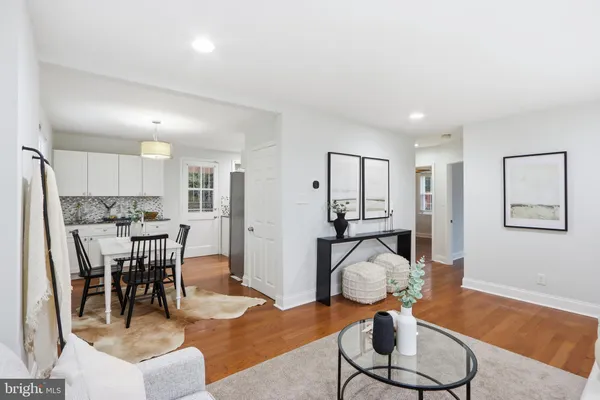 a living room with furniture a dining table and view of kitchen