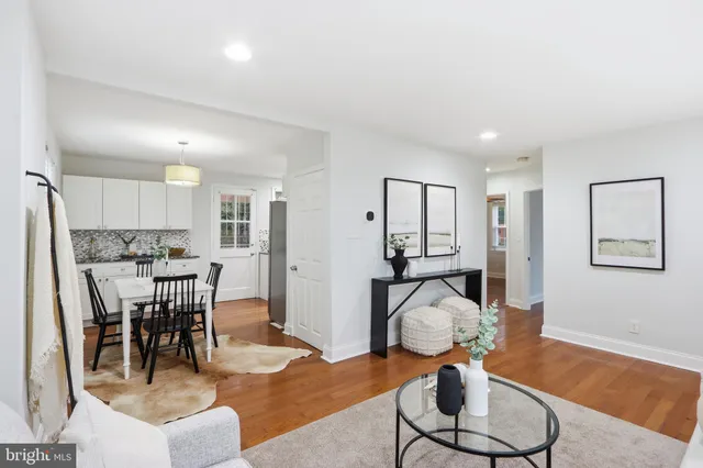 a living room with furniture a dining table and view of kitchen