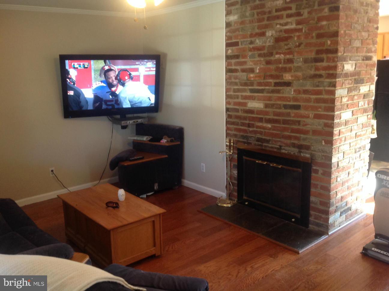 7125 Catlett Street Springfield, VA 22151 - Photo 5 of 26 Hard wood floors and wood burning fire place.