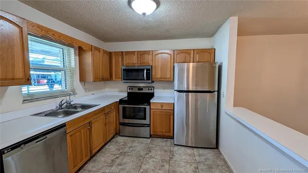 a kitchen with stainless steel appliances granite countertop a refrigerator sink and stove