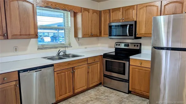 a kitchen with granite countertop a refrigerator stove and microwave