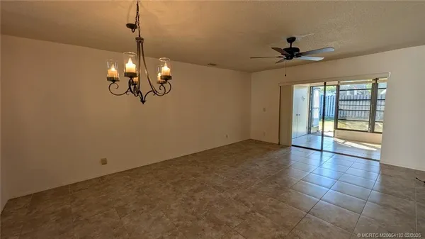a view of a livingroom with a chandelier fan and windows