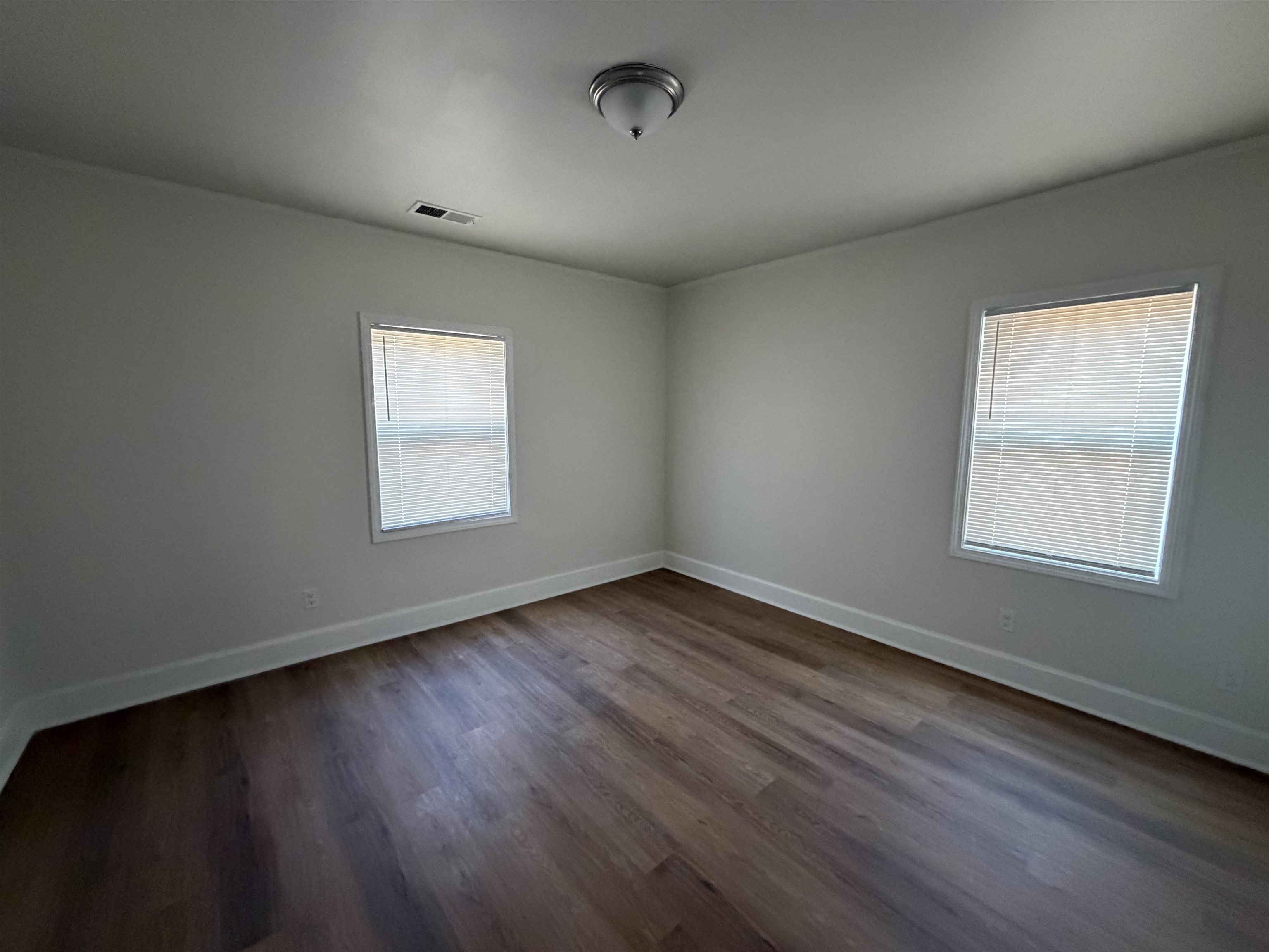 3739 Rhea Avenue Memphis, TN 38122 - Photo 3 of 10 an empty room with wooden floor and windows