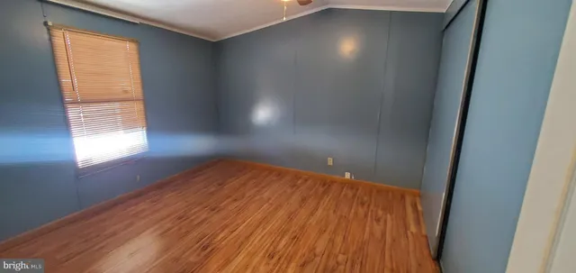 an empty room with windows and wooden floor