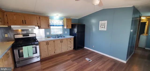 a kitchen with granite countertop wooden cabinets and a stove