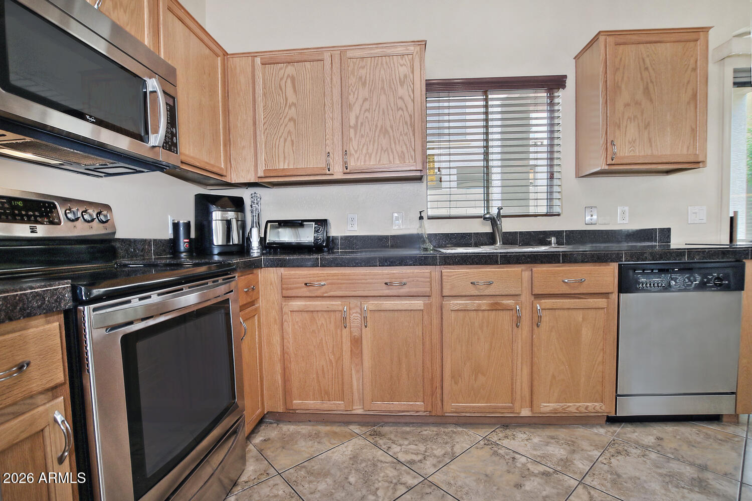 2150 East Bell Road, Unit 1069 Phoenix, AZ 85022 - Photo 11 of 33 a kitchen with stainless steel appliances granite countertop a stove a sink and a microwave