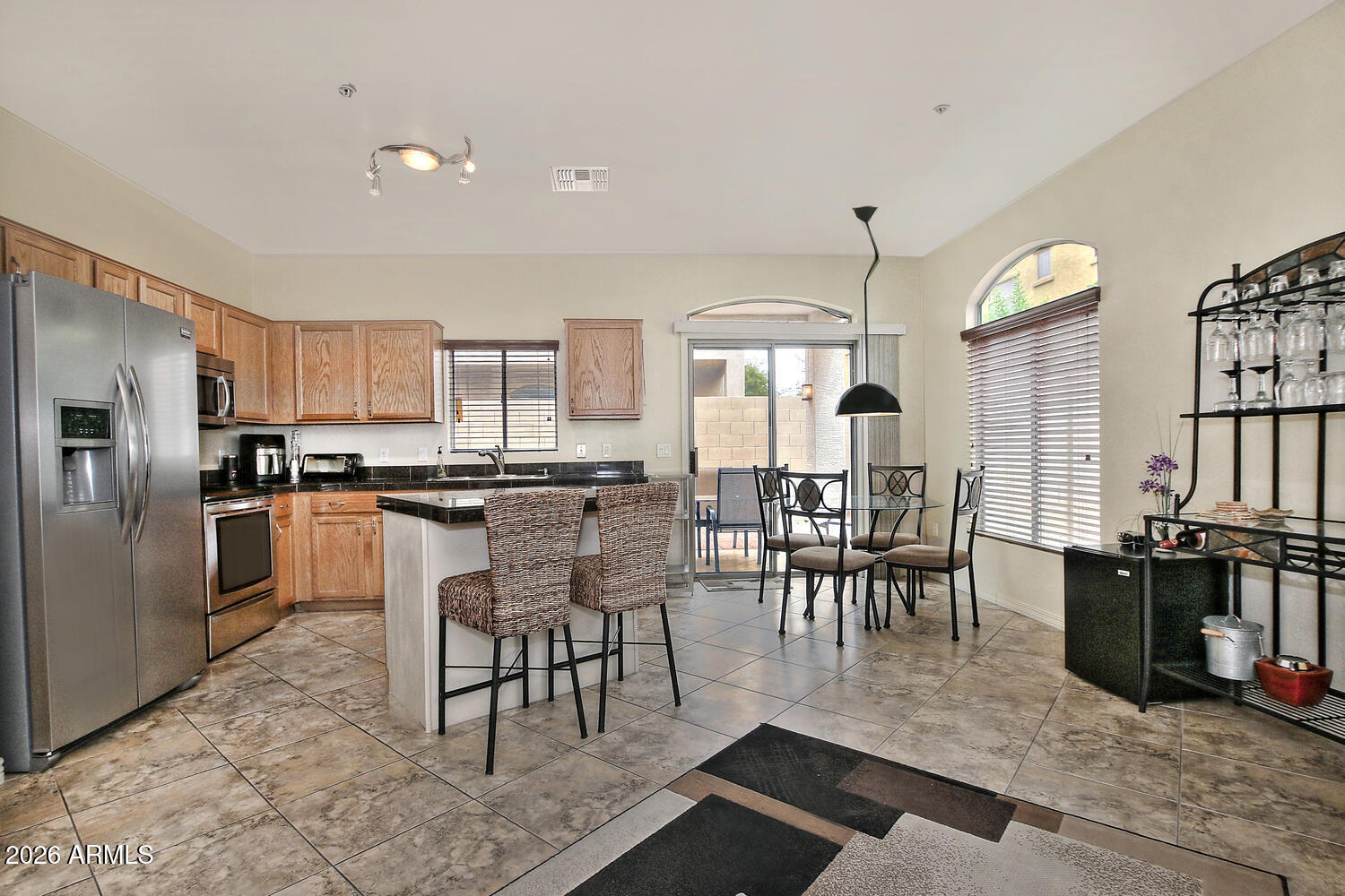 2150 East Bell Road, Unit 1069 Phoenix, AZ 85022 - Photo 7 of 33 a kitchen with a dining table chairs and refrigerator