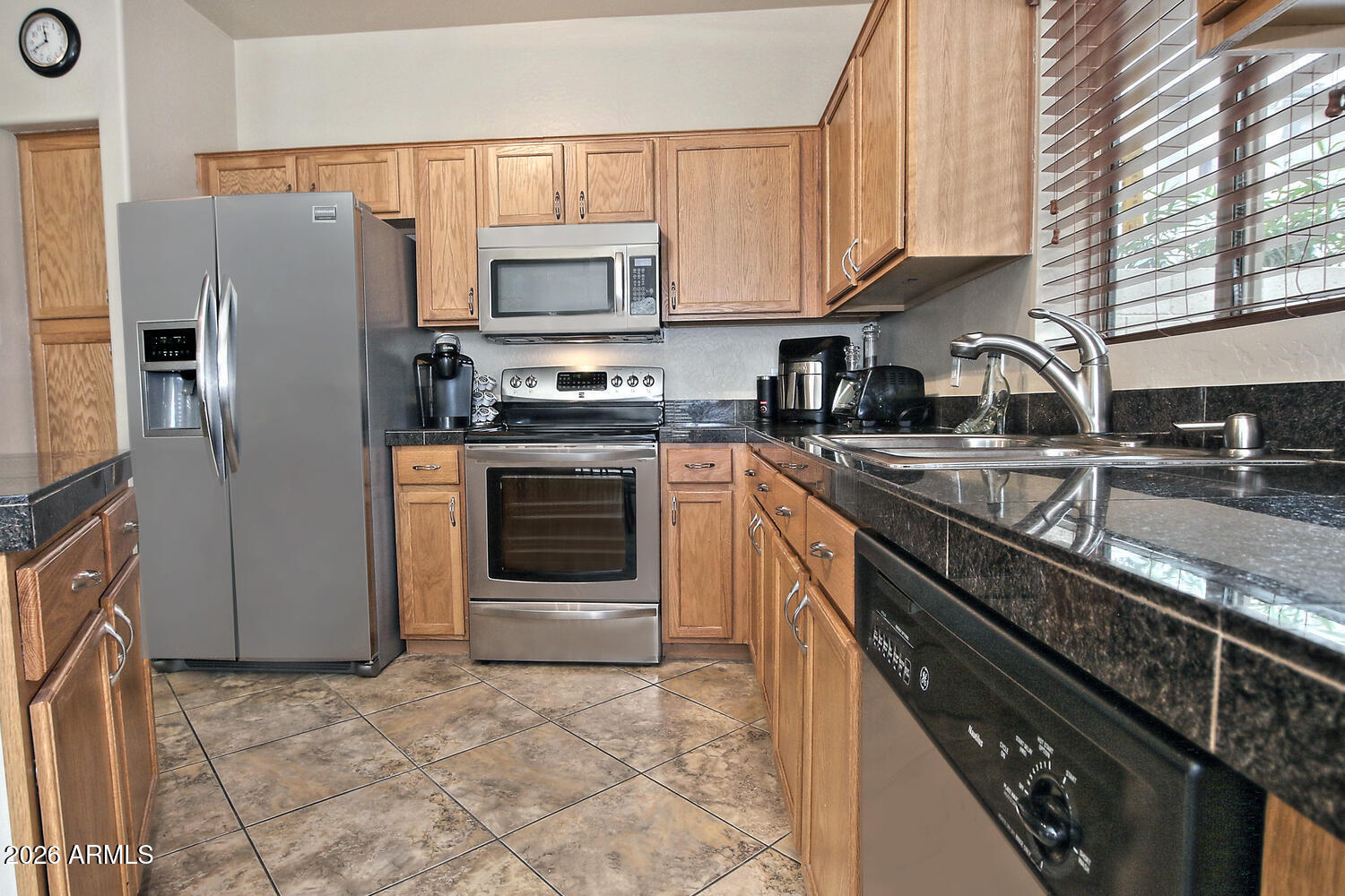 2150 East Bell Road, Unit 1069 Phoenix, AZ 85022 - Photo 10 of 33 a kitchen with stainless steel appliances granite countertop a stove top oven a sink dishwasher a refrigerator and cabinets with wooden floor