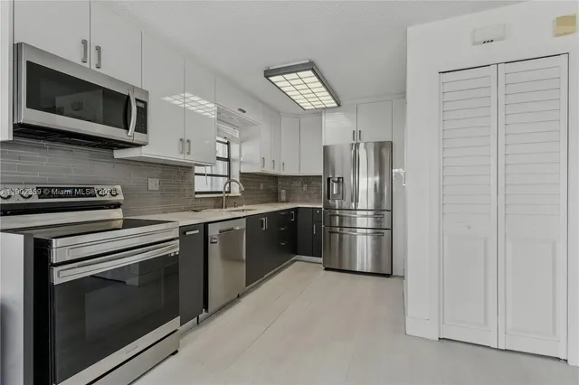 a kitchen with stainless steel appliances granite countertop a refrigerator stove and microwave