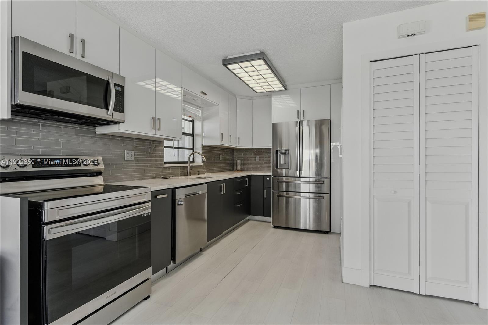 6825 Northwest 169th Street, Unit 54H Hialeah, FL 33015 - Photo 12 of 46 a kitchen with stainless steel appliances granite countertop a refrigerator stove and microwave