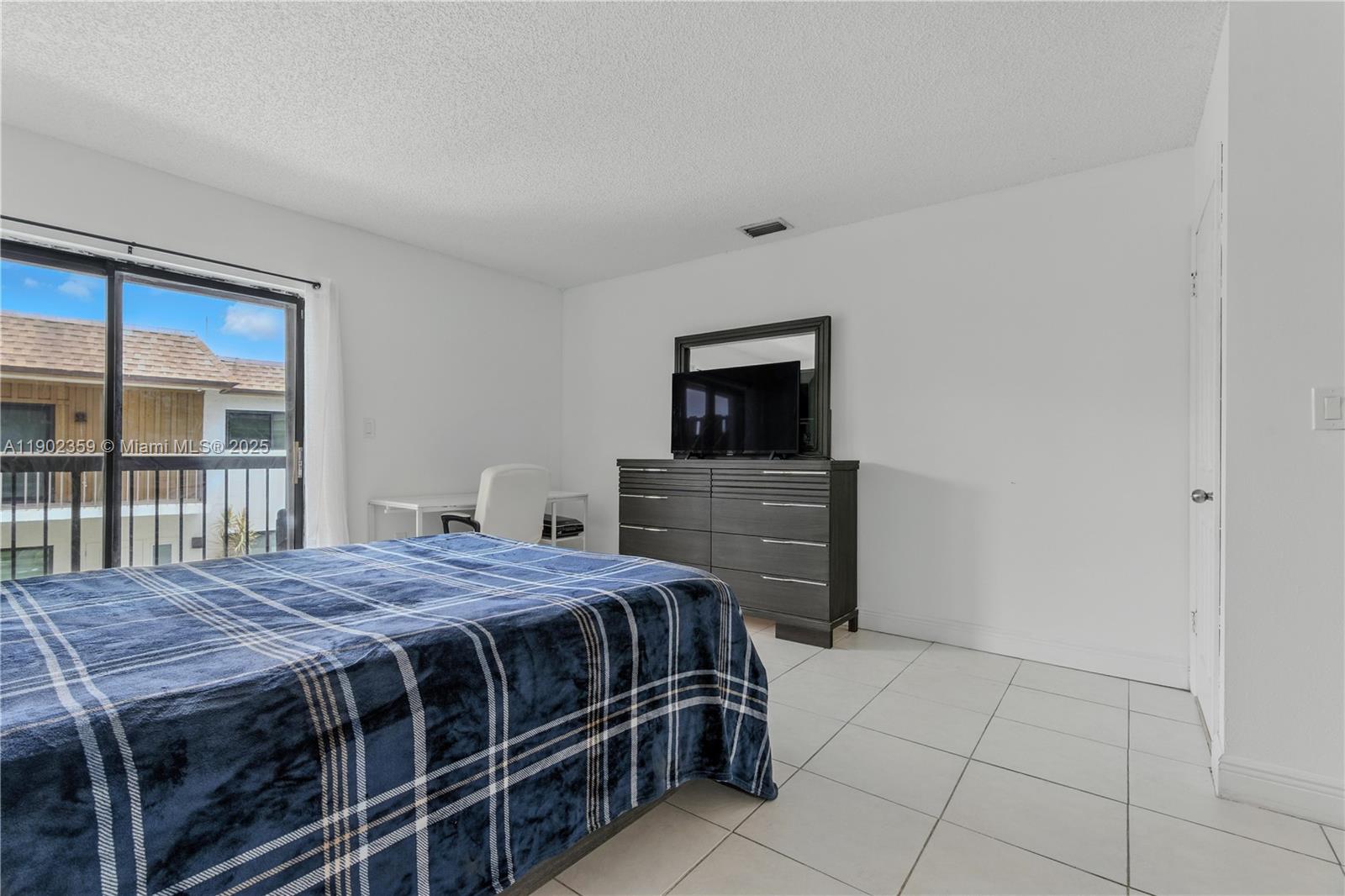 6825 Northwest 169th Street, Unit 54H Hialeah, FL 33015 - Photo 17 of 46 a bedroom with a bed and a flat screen tv