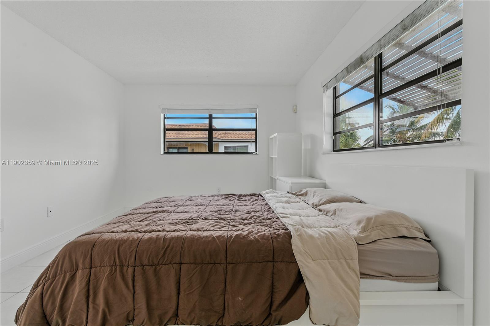 6825 Northwest 169th Street, Unit 54H Hialeah, FL 33015 - Photo 20 of 46 a bedroom with a bed and a painting on the wall