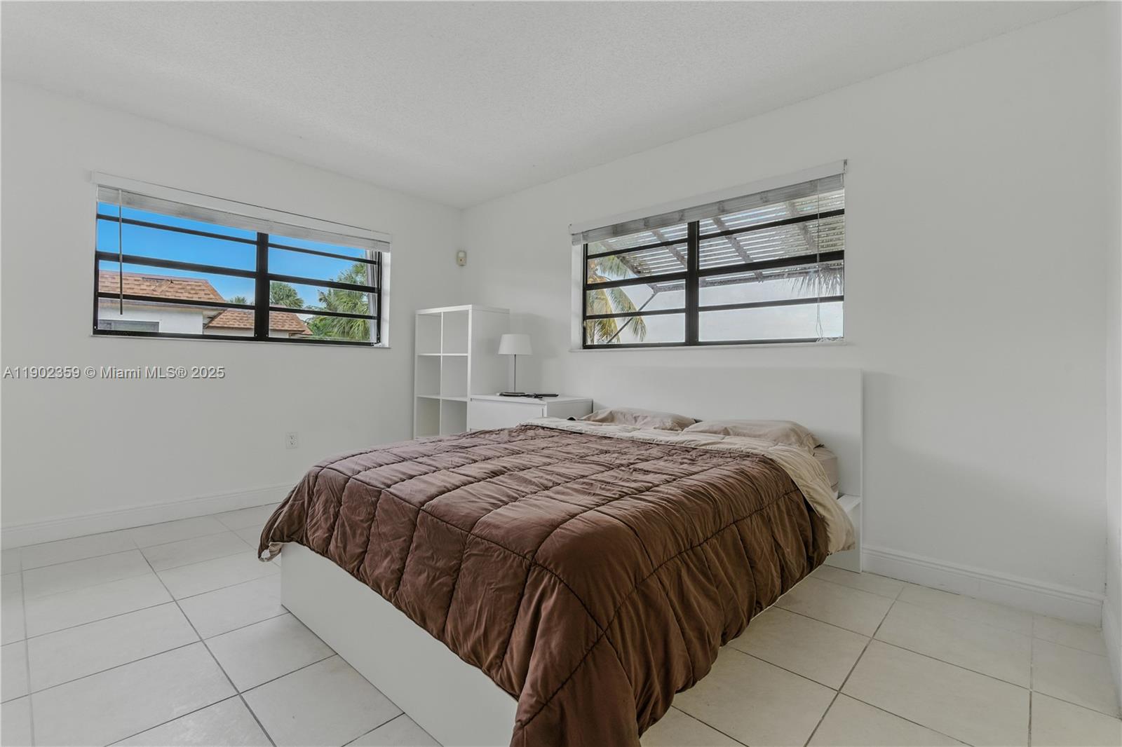 6825 Northwest 169th Street, Unit 54H Hialeah, FL 33015 - Photo 21 of 46 a bed sitting in a bedroom next to a window