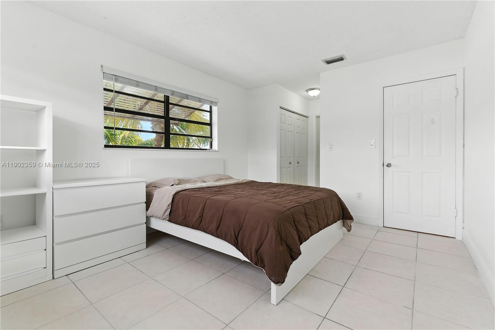 6825 Northwest 169th Street, Unit 54H Hialeah, FL 33015 - Photo 22 of 46 a bedroom with a bed and a window