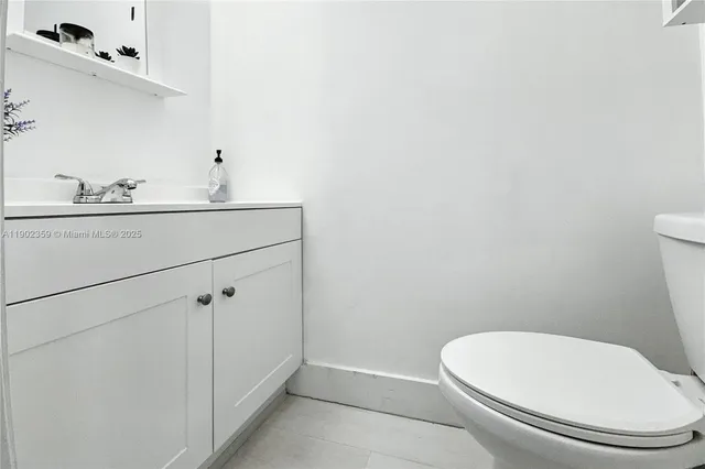 a white toilet sitting next to a bathroom sink