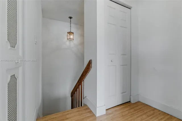 a view of a hallway with wooden floor and staircase
