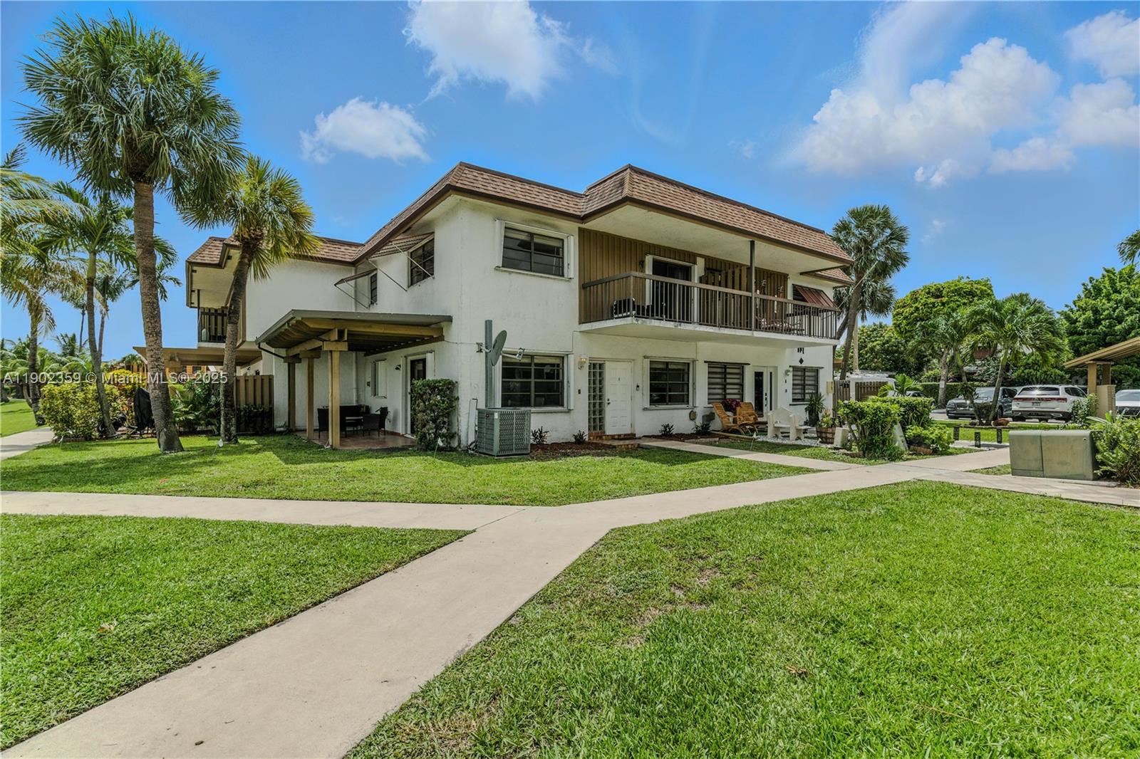 6825 Northwest 169th Street, Unit 54H Hialeah, FL 33015 - Photo 32 of 46 a front view of a house with a yard table and chairs