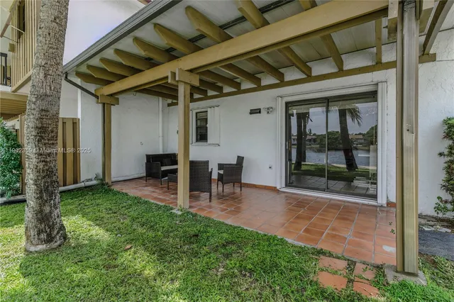 a view of a porch with table and chairs and potted plants