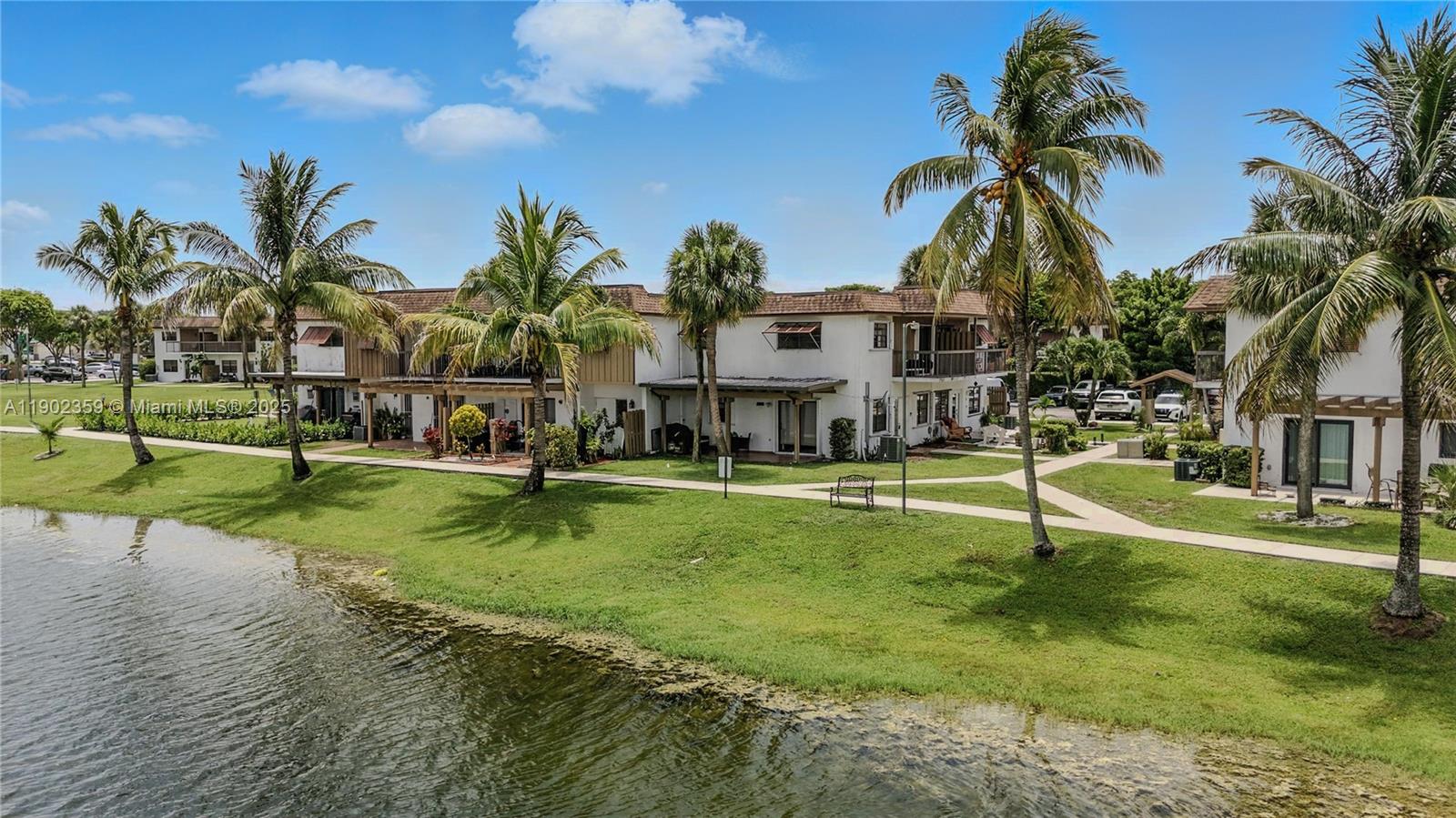 6825 Northwest 169th Street, Unit 54H Hialeah, FL 33015 - Photo 42 of 46 a view of a house with swimming pool and a yard