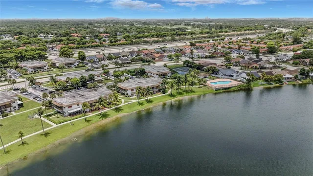 an aerial view of residential houses with outdoor space and lake view