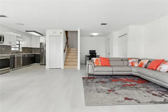 a living room with furniture and kitchen view