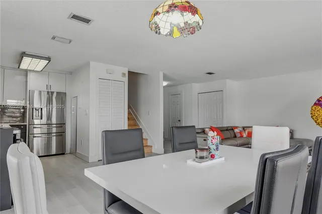 a kitchen with stainless steel appliances granite countertop a table chairs and stove top oven