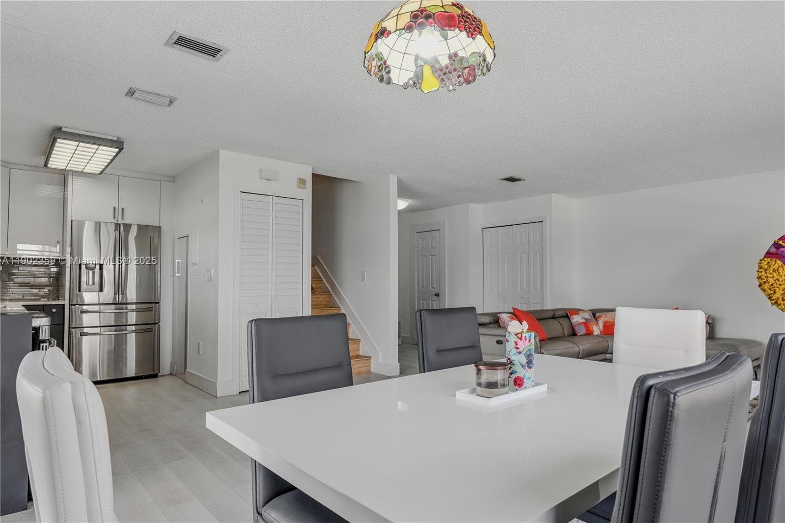 6825 Northwest 169th Street, Unit 54H Hialeah, FL 33015 - Photo 9 of 46 a kitchen with stainless steel appliances granite countertop a table chairs and stove top oven