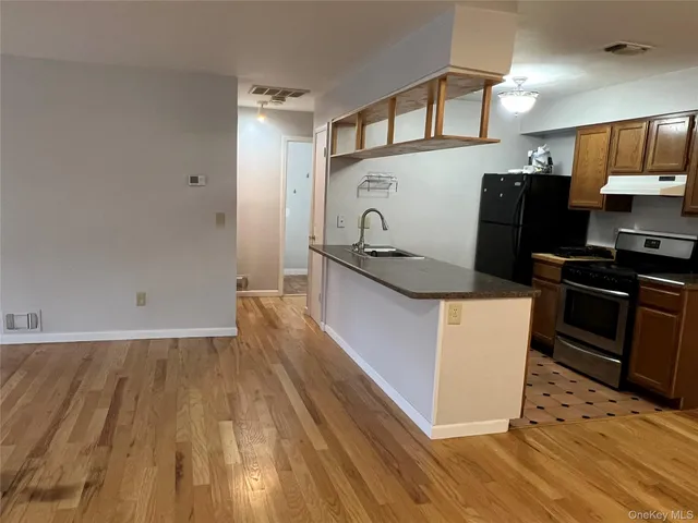 a kitchen with granite countertop a refrigerator and a stove top oven