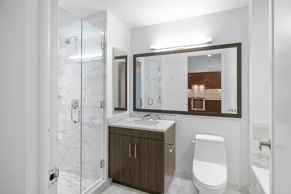 a bathroom with a toilet a sink and mirror