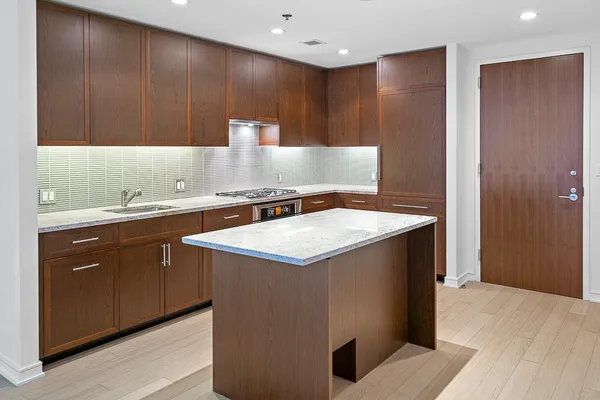 a kitchen with a sink a refrigerator and cabinets