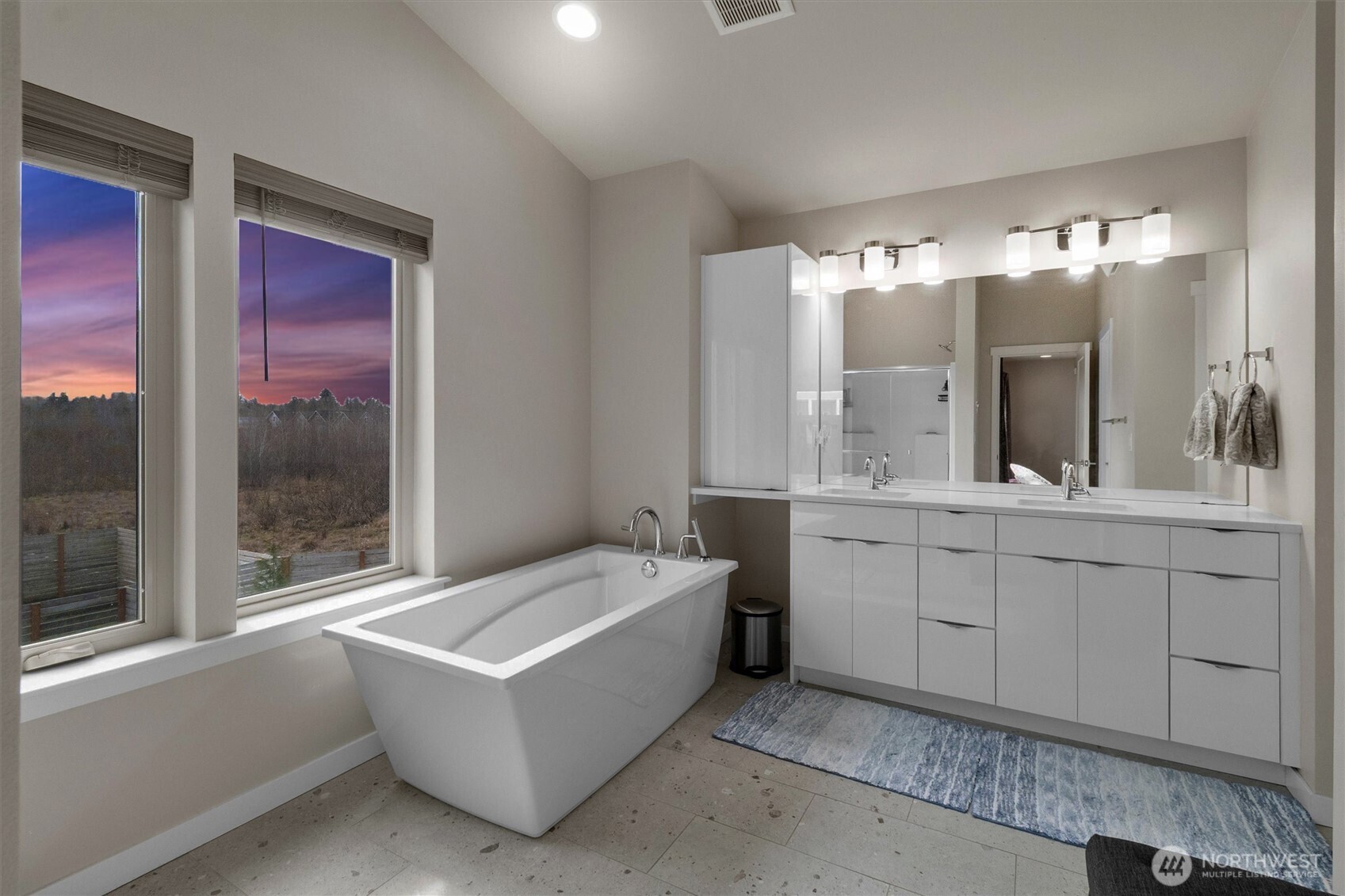 703 Northview Street Bellingham, WA 98226 - Photo 13 of 40 a en suite bathroom with a double vanity sink a large mirror and a bathtub
