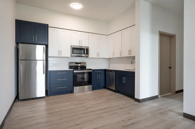 a kitchen with a refrigerator and a stove top oven