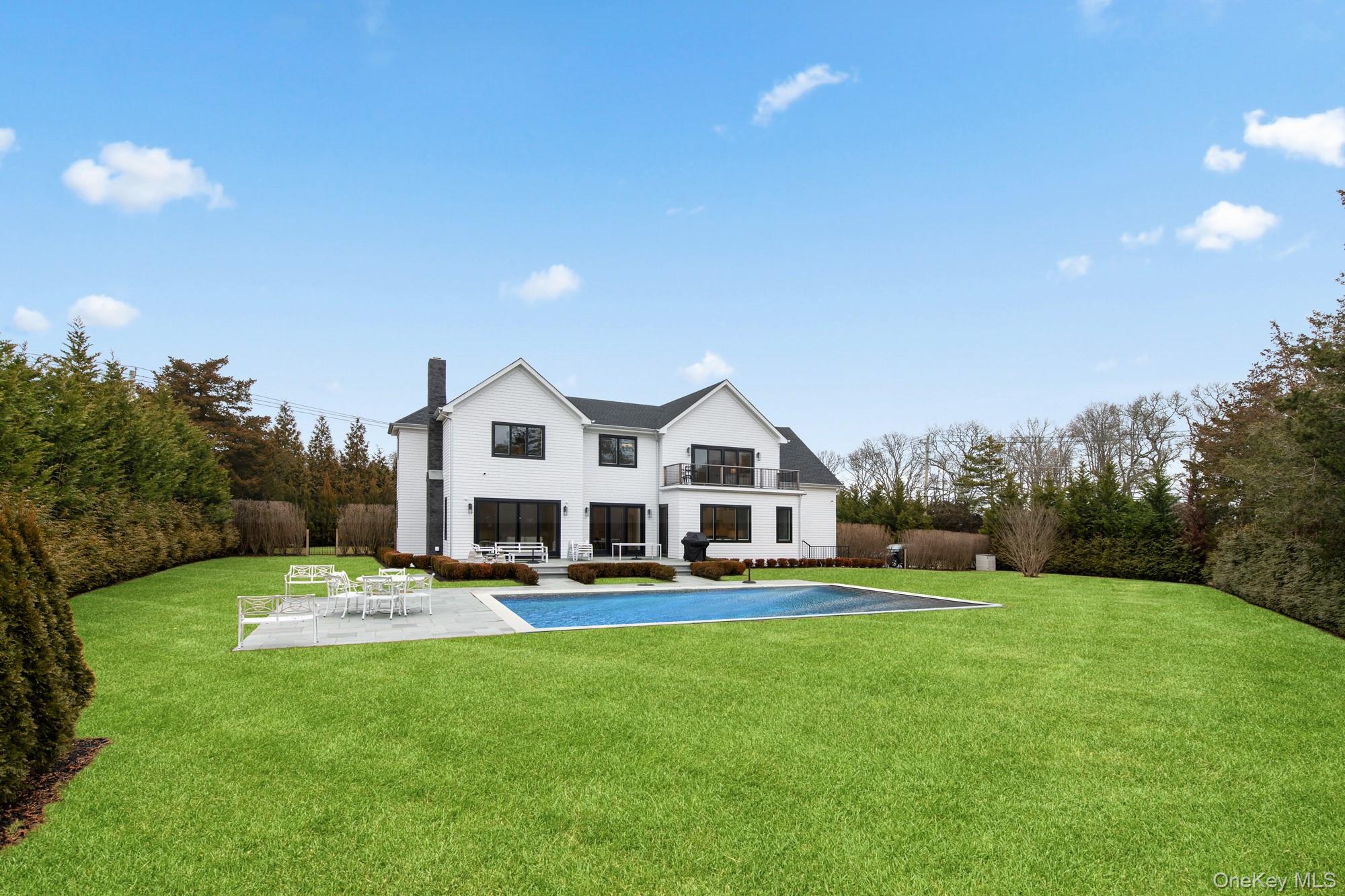 240 Head Of Pond Road Water Mill, NY 11976 - Photo 6 of 40 Rear view of house featuring a patio, a chimney, a balcony, and a lawn