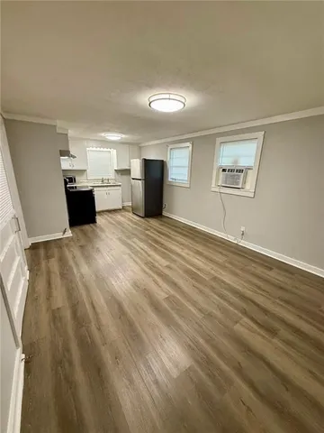 an empty room with wooden floor and fireplace