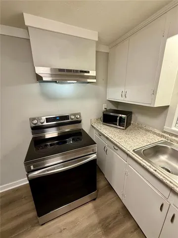 a kitchen with granite countertop a stove and a sink