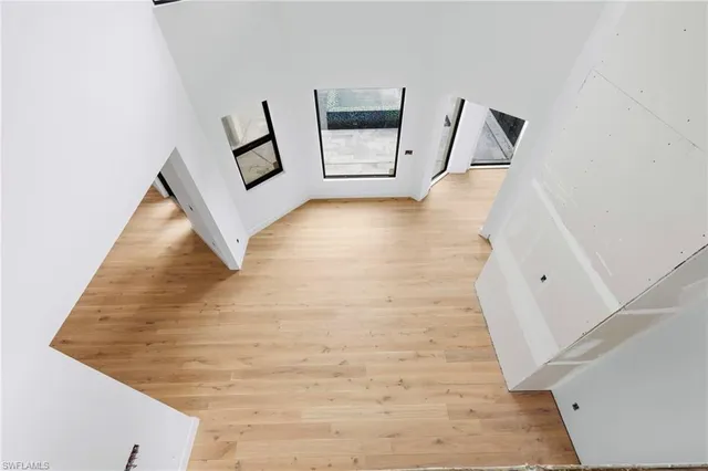 a view of a hallway with wooden floor and a large window