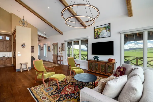 a living room with furniture a flat screen tv and a large window