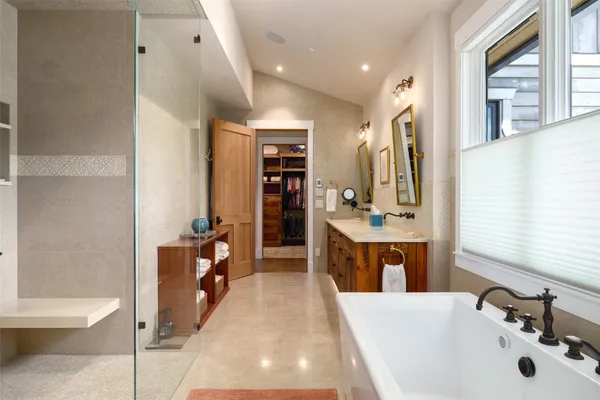 a bathroom with a tub sink and mirror