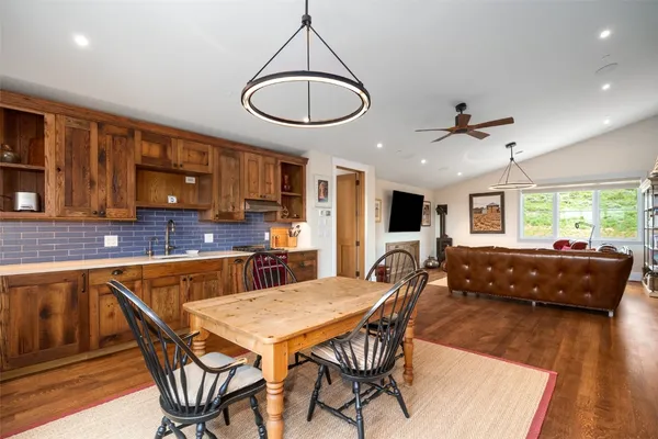 a living room with stainless steel appliances furniture a dining table and kitchen view