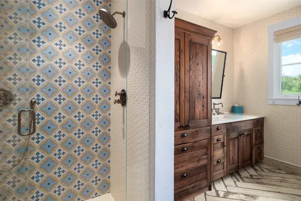 a bathroom with a sink a mirror and a shower