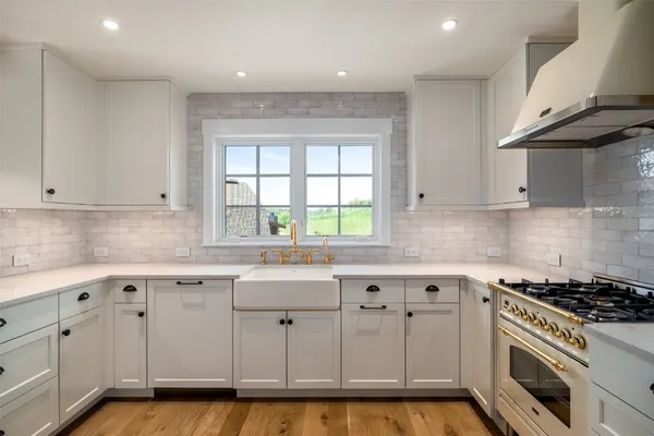 a kitchen with stainless steel appliances granite countertop a sink and cabinets with wooden floor