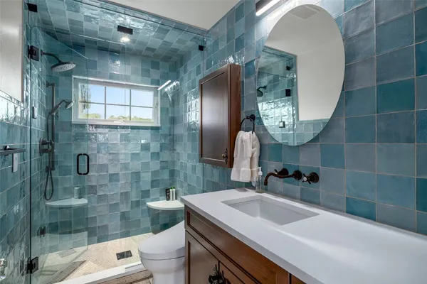 a bathroom with a sink a toilet and shower