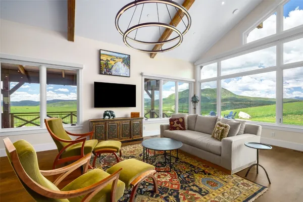 a living room with furniture a flat screen tv and a floor to ceiling window
