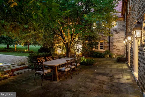 a backyard of a house with table and chairs plants and trees