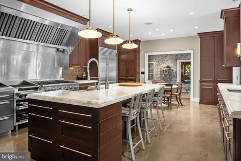 a kitchen with stainless steel appliances granite countertop a stove a sink and a dining table