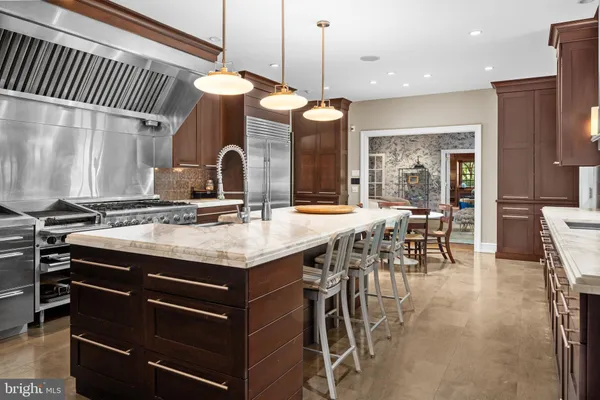 a kitchen with stainless steel appliances granite countertop a stove a sink and a dining table