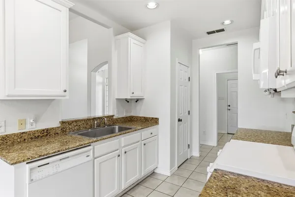 a spacious bathroom with a granite countertop sink and a mirror