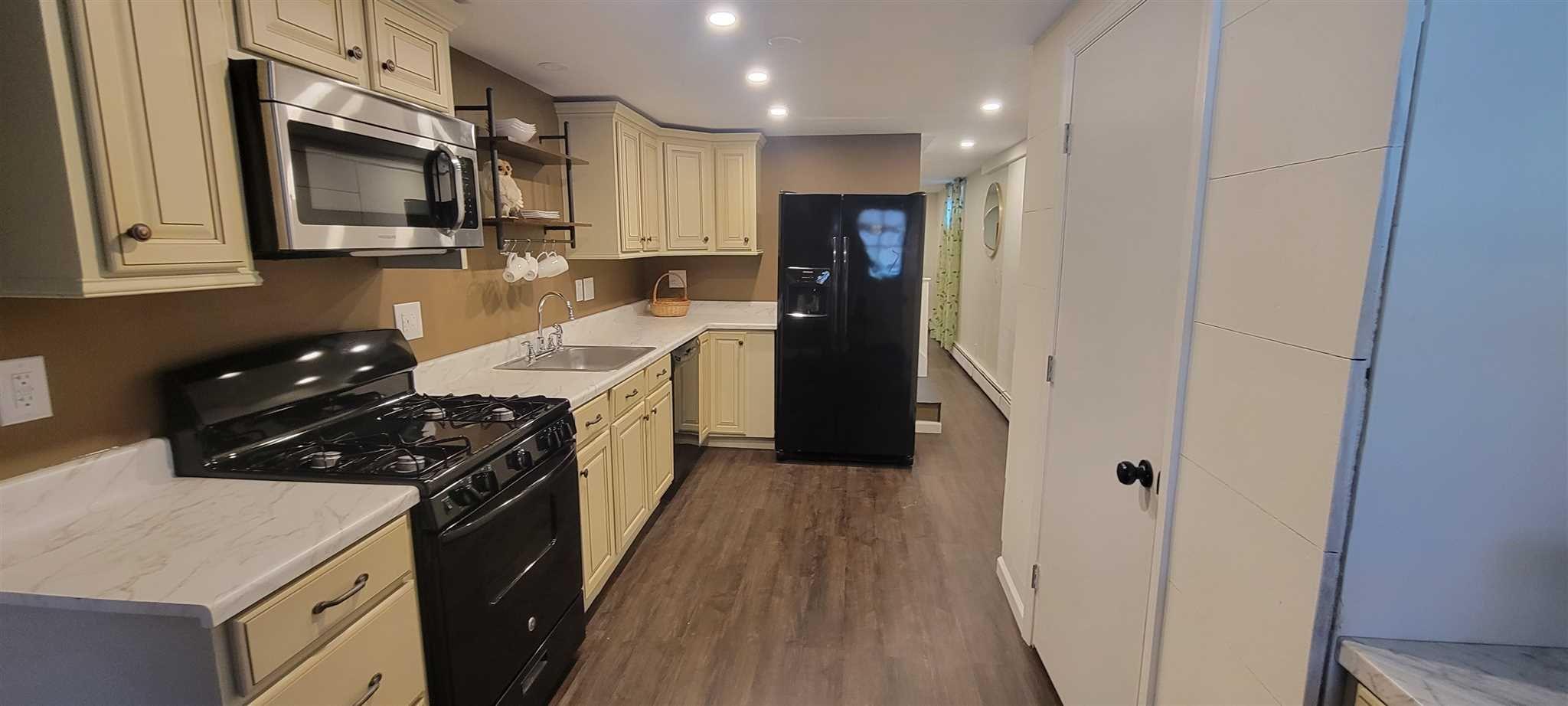 5 Haymaker Lane Plattekill, NY 12589 - Photo 27 of 37 a kitchen with stainless steel appliances a refrigerator a sink a stove top oven a wooden floor and cabinets